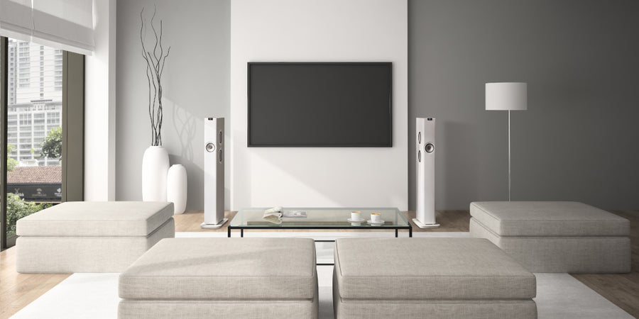 KEF LS60 Wireless en Mineral White installées de part et d'autre d'un grand téléviseur mural dans un salon.