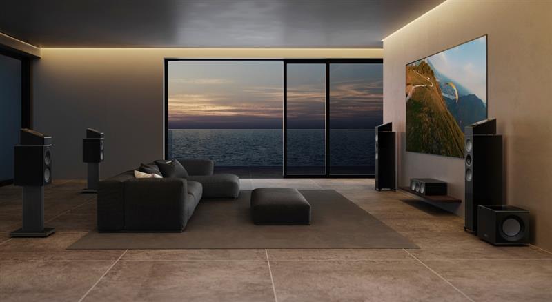 Barre de son KEF placée sous un téléviseur mural dans un salon moderne pour une expérience home cinéma immersive