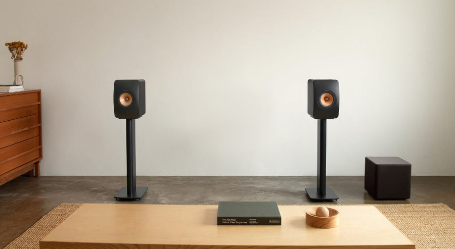  Enceintes bibliothèque KEF sur pieds avec caisson de basses noir compact dans un salon moderne minimaliste