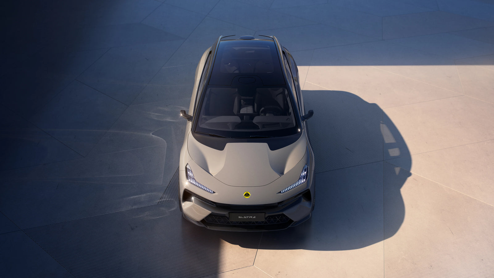 A top-down view of the Lotus Eletre parked on a concrete surface under direct sunlight.